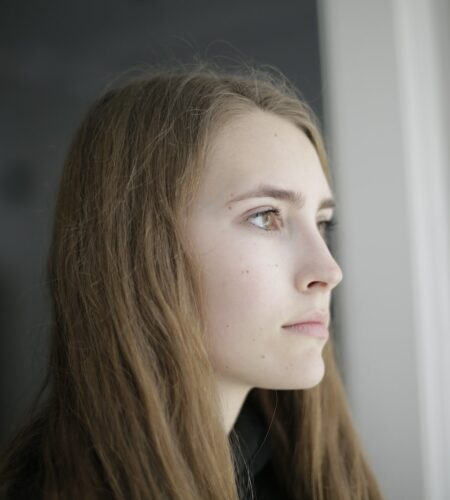 Pensive young woman in living room