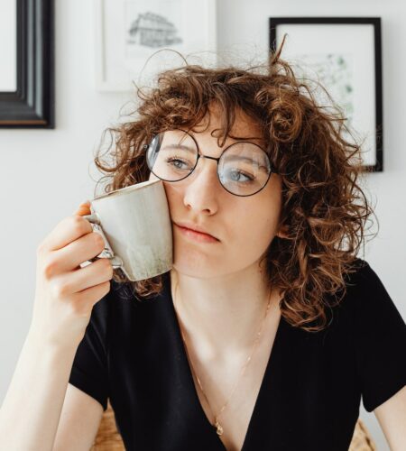 Curly-Haired Woman Holding a Coffee Mug